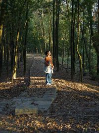 Full length of woman standing in forest