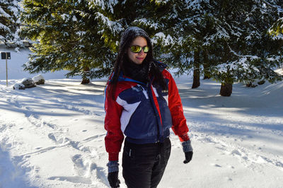 Full length of woman standing on snow covered land