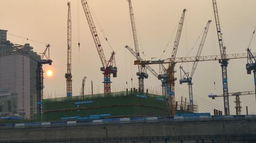 Cranes at commercial dock during sunset