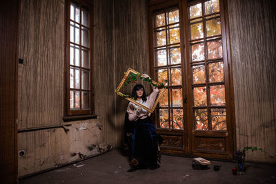 Full length of woman sitting at window