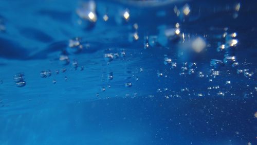 Close-up of water drops on blue surface