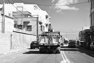 Vehicles on road against buildings in city