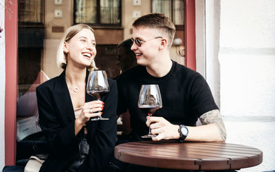 Young couple sitting in a drinking glass