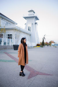 Full length of a woman standing in front a lighthouse