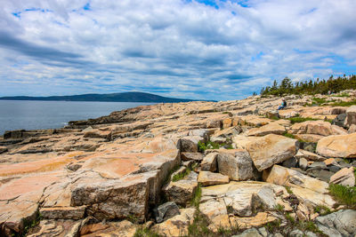 Scenic view of rocky beach against sky