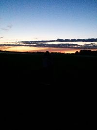 Silhouette man on field against clear sky