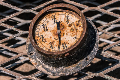 Close-up of rusty gauge on fence