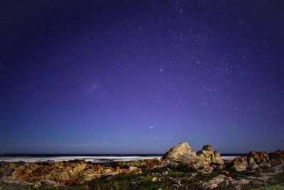 Scenic view of sea against star field at night