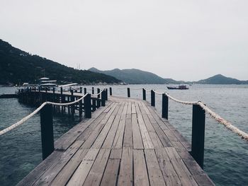 Wooden pier over sea against clear sky