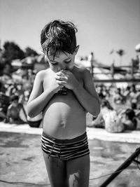 Full length of shirtless boy standing at beach