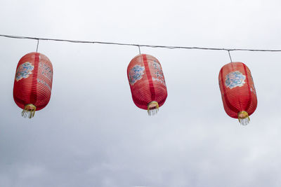 Low angle view of lanterns hanging against sky