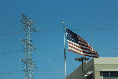 Low angle view of flag against clear blue sky