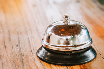 Close-up of service bell on wooden table