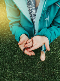 Cute caucasian preschool girl holding rain worm in hands. child kid learning studying nature around.