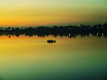 Scenic view of river against sky at sunset