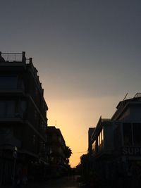 Buildings against clear sky at sunset