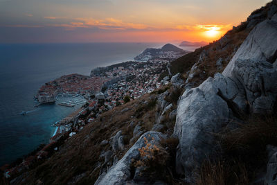 Scenic view of sea and old town dubrovnik against sky during sunset