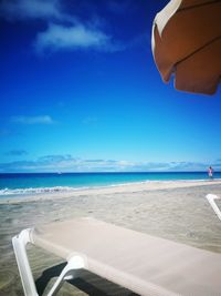 Scenic view of beach against blue sky