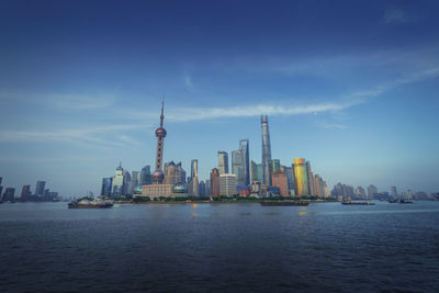 Sea and buildings in city against sky