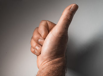 Close-up of human hand against wall