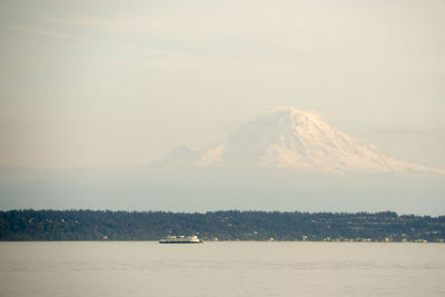 Boats in sea with mountain range in background