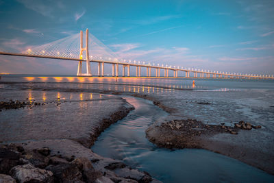 Suspension bridge over sea against sky