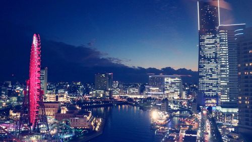 Illuminated buildings in city against sky at night