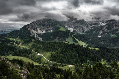 Scenic view of mountains against sky with dark clouds