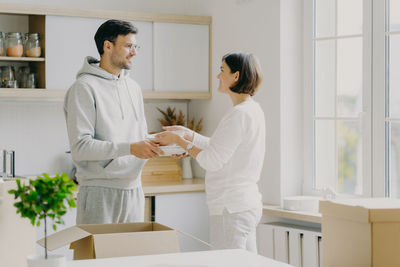 Couple looking at each other while standing at new home