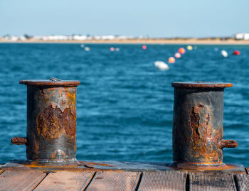 Close-up of rusty metal railing against sea