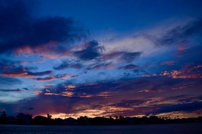 Scenic view of dramatic sky over silhouette landscape