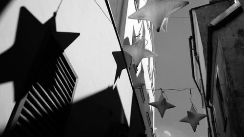 Low angle view of flags hanging against built structure