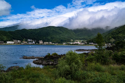 Scenic view of lake by trees against sky