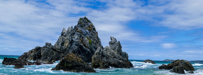 Rock formation on beach against sky