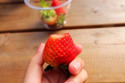 Cropped image of hand holding strawberry