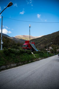 Road by mountain against blue sky