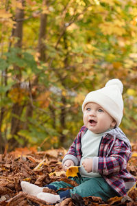 Portrait of cute boy standing in forest