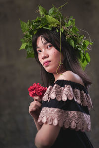 Beautiful woman standing by red rose