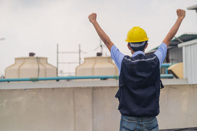 Rear view of man standing against wall