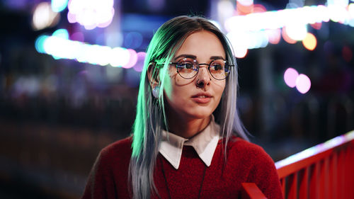 Portrait of young woman wearing sunglasses standing outdoors