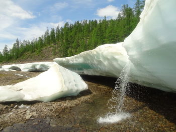 Scenic view of waterfall against sky