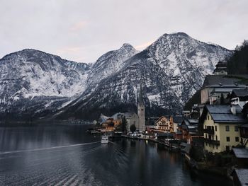 Scenic view of lake by snowcapped mountains against sky