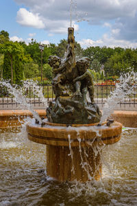 Fountain in water against sky