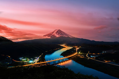 View of illuminated bridge against cloudy sky at sunset