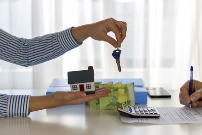 Real estate agent and customer signing a contract to buy a house with land and insurance. 