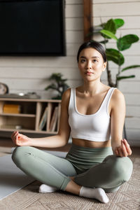 Portrait of young woman sitting on sofa at home