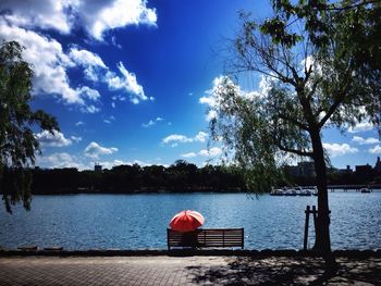 Rear view of people sitting on lakeshore