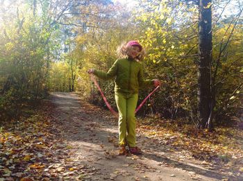 Full length of woman standing in forest