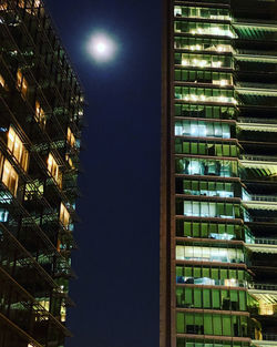 Low angle view of illuminated buildings against sky at night