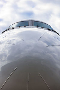 Cockpit of jet airplane against blue cloudy skies